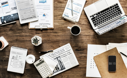 Image by rawpixel from Pixabay. Grafika prezentująca biurko, na którym leżą dokumenty, kalkulator, komputer, długopis oraz telefon, biurko wyglada jak podczas prasy biurowej