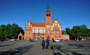 Zdjęcie Ratusza, kobiety na Placu Zwycięstwa idące w kieunku Ratusza