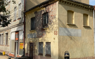 Zdjęcie przedstawia nieruchomość zabudowaną budynkiem dwukondygnacyjnym przeznaczoną na sprzedaż