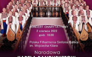 Na zdjęciu widzimy plakat z zapowiedzią KONCERTU CHARYTATYWNEGO - TREŚĆ ZGODNA Z ARTYKUŁEM, oraz kilkadziesiąt osób z instrumentami muzycznymi