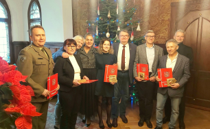 Olimpijczycy wspólnie z Prezydentką Słupska i Pełnomocnikiem ds.Sportu. Na pierwszym planie gwiazda betlejemska, w tle choinka