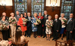 Julilaci i Prezydentka Słupska w sali ratusza, w tle lampy i witraże