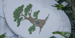 zdjęcie przedstawiające rysunek drzewa na wyciętej kartce przewiązanej na dole zieloną wstążką - forma zawieszki