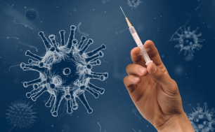 (fot. pixabay) na granatowym tle wirus a obok ręka trzyamająca strzykawkę