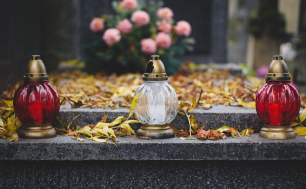 Groby zmarłych udekorowane kwiatami i zniczami.