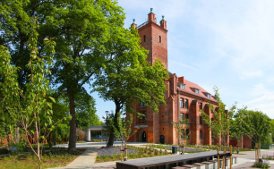 Budynek Biblioteki z czerwonej cegły w otoczeniu zielonych drzew