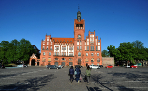 Na zdjęciu widdać ratusz, pl.Zwycięstwa kilka samochodów i przechodniów