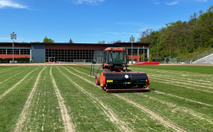 Traktor pracuje na zielonej płycie stadionu 650-lecia w Slupsku.