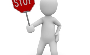 na białym tle szary ludzik trzymający w prawej ręce czerwony znak z białym napisem stop  fot: pixabay