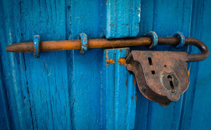 zdjęcie przedstawia metalową kłódkę zamykającą niebieskie drzwi (fot. pixabay)