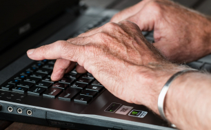ręce seniora na klawiaturze komputera