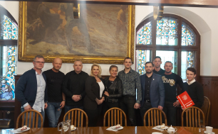 Na zdjęciu widzimy 10 osób, SPonsorów Gali , Pana Tomasz Mazura oraz Prezydentkę Słupska; wszyscy stoją  przy stole, za nimi okna i obraz