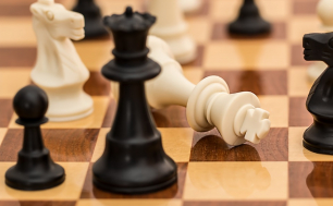 zdjęcie przedstawia szachownicę, na której znajdują się czarne i białe figury (fot.pixabay)