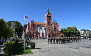 zdjęcie poglądowe, w tle ratusz, na pl. Zwycięstwa Wojsko RP, uczestnicy ur. z lat ubiegłych, pomnik Żołnierza Polskiego i miejska zieleń