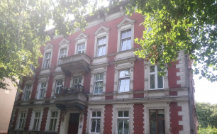 Zdjęcie przedstawia budynek, w którym znajduje się lokal mieszkalny na sprzedaż.