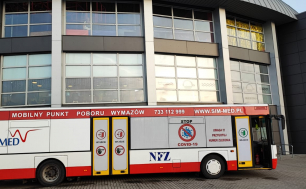 Zdjęcie przedstawia autobus (Mobilny Punkt Poboru Wymazów) stojący pod Parkiem Wodnym "Trzy Fale"