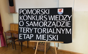 Zdjęcie przedstawia planszę z nazwą konkursu oraz herb Słupska