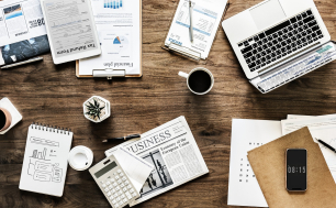 Image by rawpixel from Pixabay. Grafika prezentująca biurko, na którym leżą dokumenty, kalkulator, komputer, długopis oraz telefon, biurko wyglada jak podczas prasy biurowej