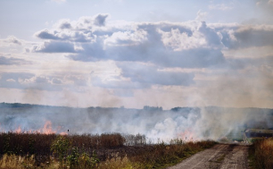 pożar łąki, dym, niebo pełne chmur