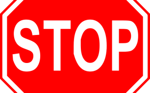 Znak STOP. Białe litery na czerwonym tle.