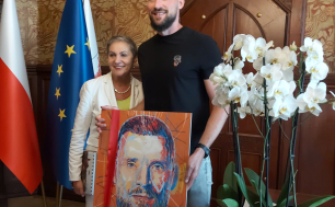 Paweł Leończyk trzyma obraz autorstwa Wojciecha Stefańca, swój portret, wspólnie z Panią Prezydent Słupska